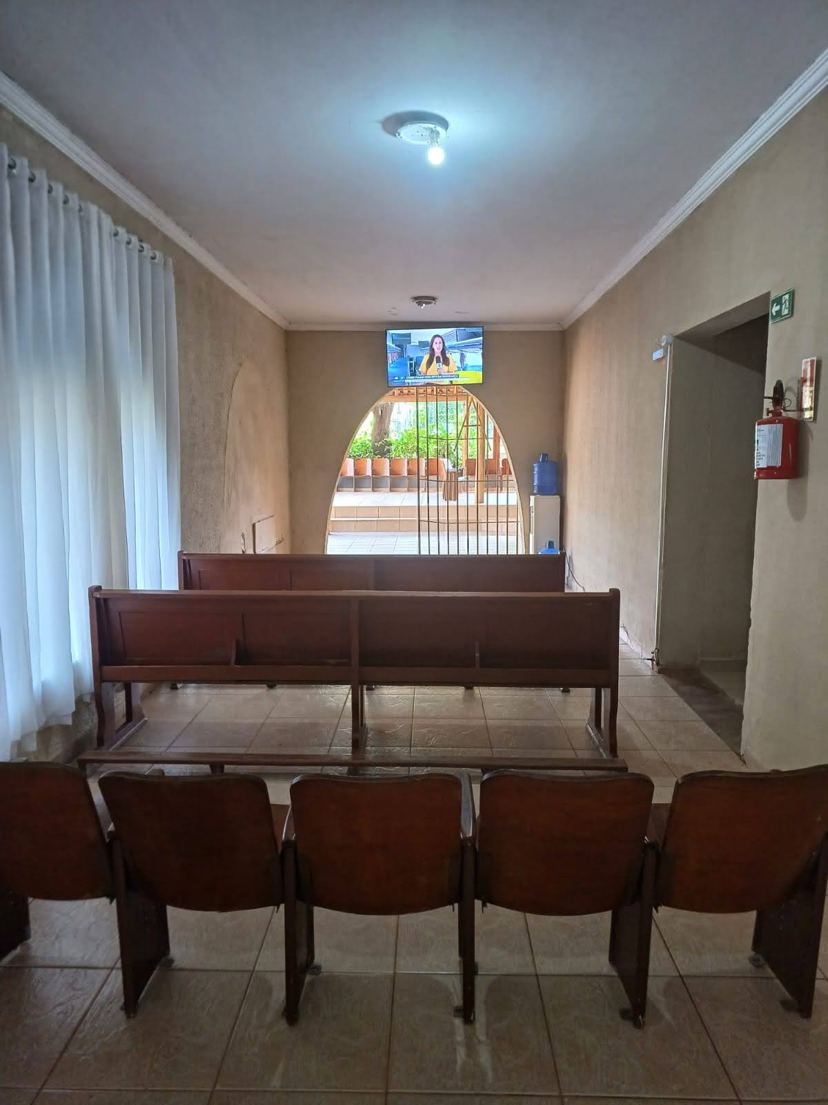 Sala com bancos e TV da Unidade 1, em Americana